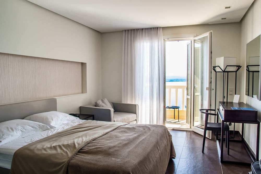 Quarto de hotel moderno com varanda e vista para a água